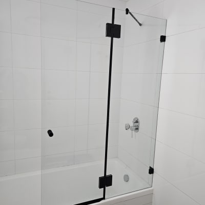 מקלחון זכוכית עם דלתות שחורות וברז כרום