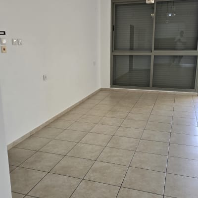 חדר ריק עם רצפת אריחים ותאורה תלויה