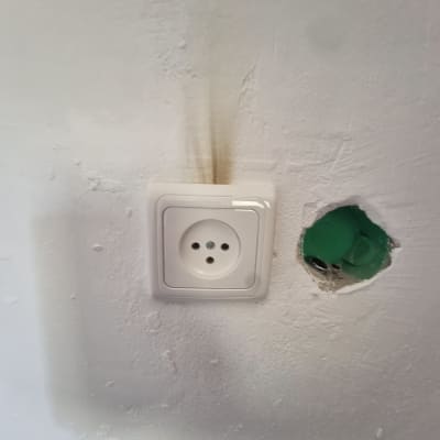 שקע חשמלי על קיר עם סימני עשן