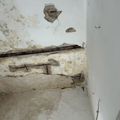 קיר עם טיח מתקלף וחוט חשמל חשוף