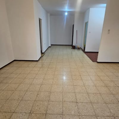 חדר ריק עם קירות לבנים וכלי ניקוי בפינה