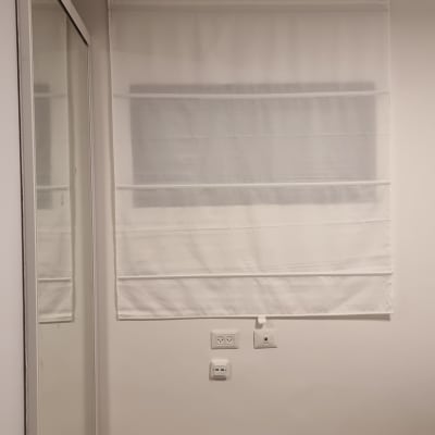 וילון לבן תלוי על קיר עם שקעי חשמל