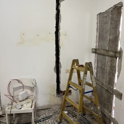 כבלים וכלים על כיסא ליד קיר עם חציבה