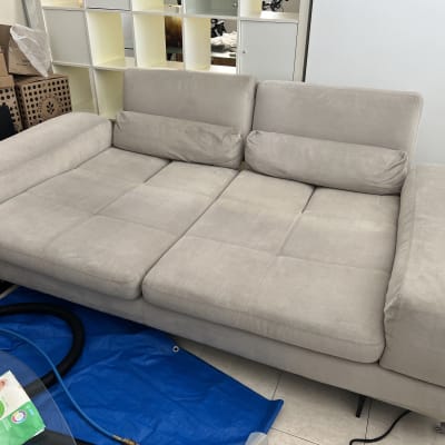 ספה אפורה עם צינור ניקוי ומטליות לחות