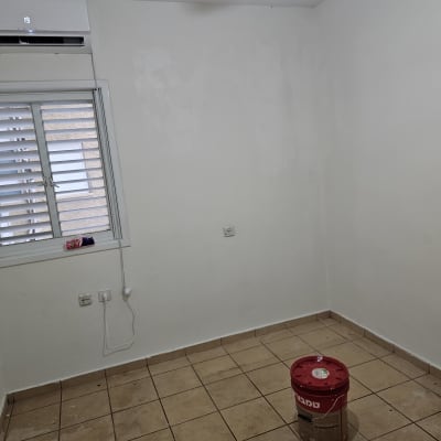 חדר צבוע עם דלי צבע על הרצפה