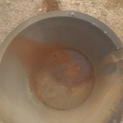 דלי מתכת חלוד על רצפה חולית