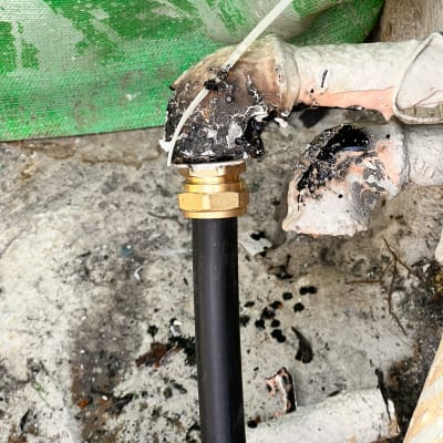 צינור שחור מחובר למתאם פליז על רקע ירוק