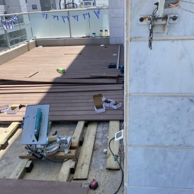 עבודות עץ על מרפסת עם כלי עבודה וחומרים
