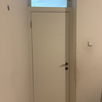 דלת לבנה עם חלון עליון בקיר פנימי