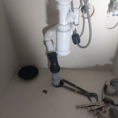 כלי עבודה וצנרת מתחת לכיור במטבח