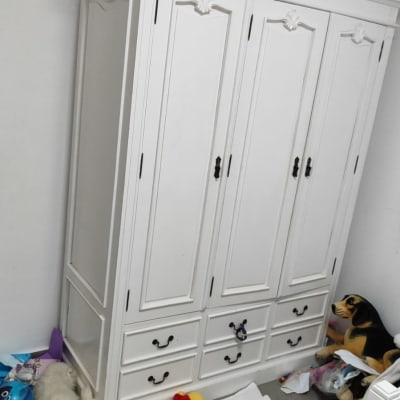 ארון לבן עם מגירות וצעצועים מפוזרים על הרצפה