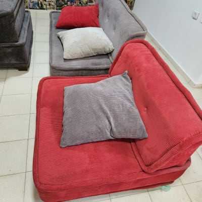 ספות אדומות ואפורות עם כריות על רצפה בהירה