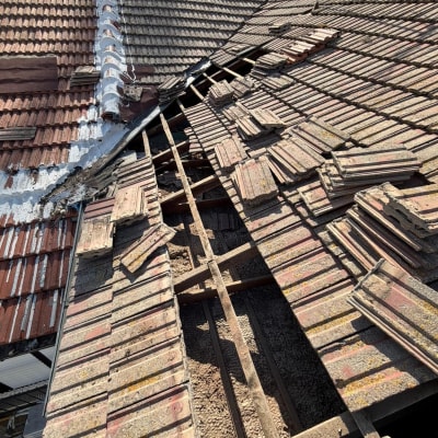 תמונה של גג רעפים פגום עם רעפים שבורים וחסרים