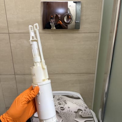 יד עם כפפה כתומה מחזיקה חלק של אסלה