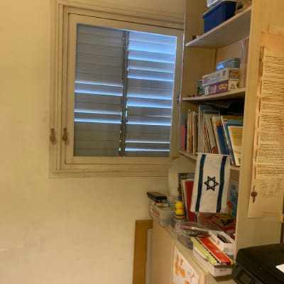 חלון זכוכית עם תריסים סגורים בחדר