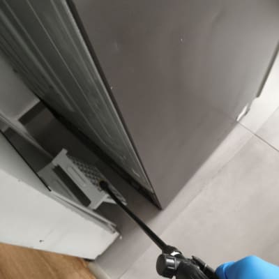 ריסוס מתחת למכשיר עם כפפה כחולה