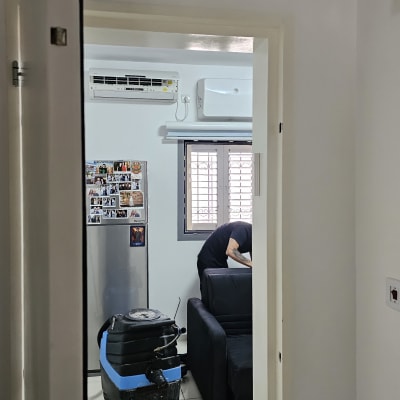 מכונת ניקוי ספות ליד ספה שחורה בחדר