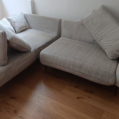 ספה אפורה עם כריות על רצפת עץ