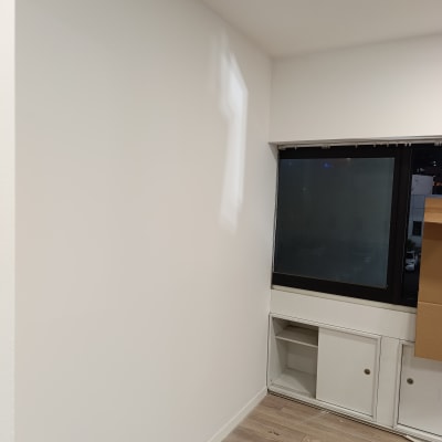 קיר צבוע לבן עם חלון ורצפת עץ