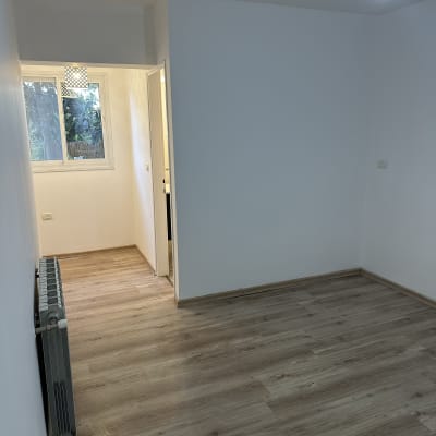 קירות צבועים בלבן בחדר ריק עם רצפת עץ