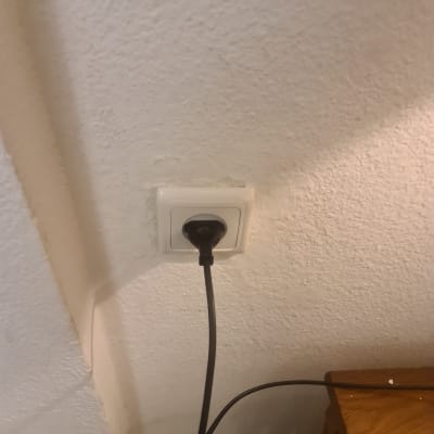 שקע חשמלי עם תקע מחובר לקיר לבן