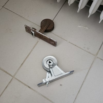 חלקי תריסים על רצפה ליד רדיאטור