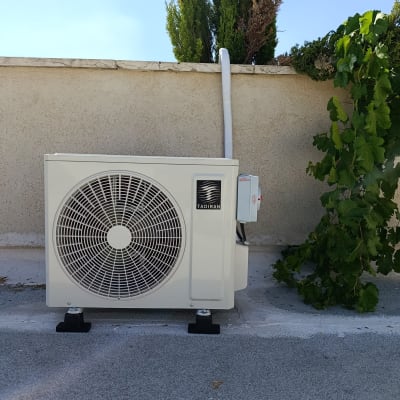 יחידת מיזוג אוויר חיצונית על גג ליד צמחייה