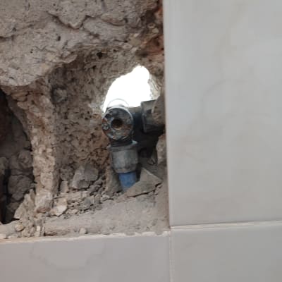 צינור מים חשוף בקיר שבור עם חיבורים