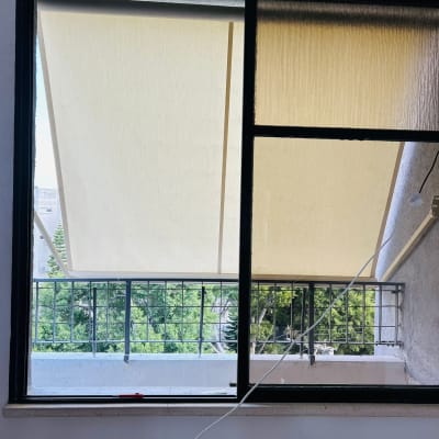 סוככים מותקנים על מרפסת עם נוף לעצים