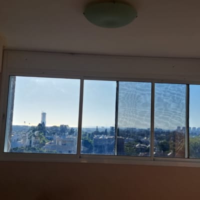 חלון אלומיניום עם נוף עירוני ברקע