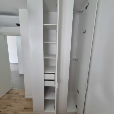 ארון לבן עם דלתות פתוחות ומדפים בפנים