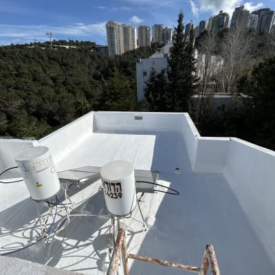 גג אטום עם ציפוי לבן ומיכלים על מתקן