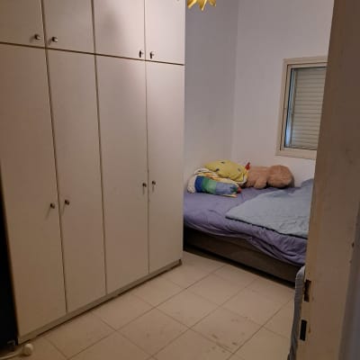 חדר שינה עם ארון בגדים ומיטה מסודרת