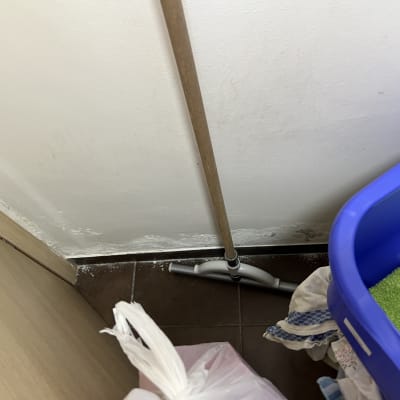 קיר עם סימני רטיבות ומגב על הרצפה