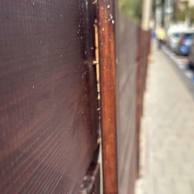 גדר עץ חומה לאורך מדרכה בעיר