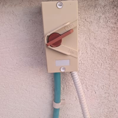 מתג חשמלי על קיר עם צינור ירוק