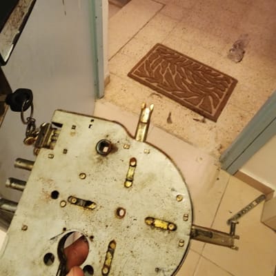 מנעול ישן מפורק על רקע דלת פתוחה