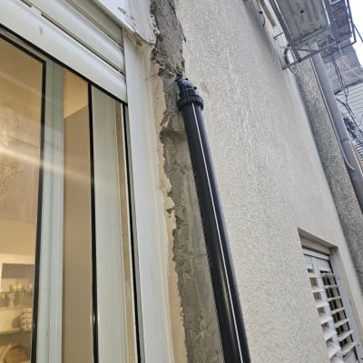 תמונה של קיר חיצוני עם צינור ותיקון טיח