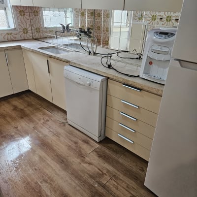 מטבח נקי עם מדיח כלים ומשטח עבודה מסודר