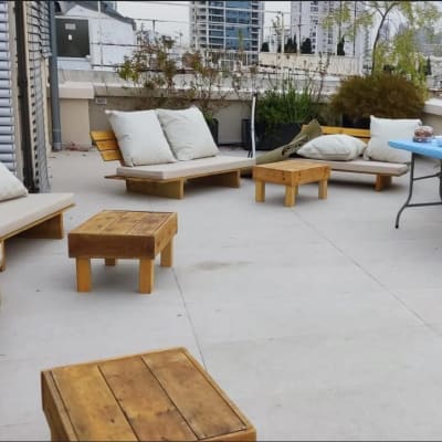 ריהוט גן מעץ עם שולחנות נמוכים וכריות לבנות