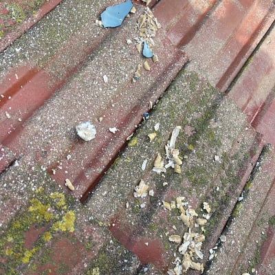 חלקי דוד שמש שבור על גג רעפים אדום