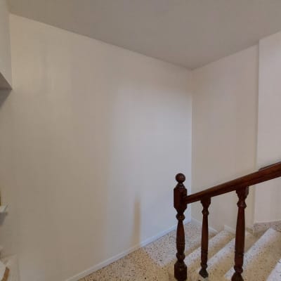 קיר גבס לבן ליד מדרגות עץ