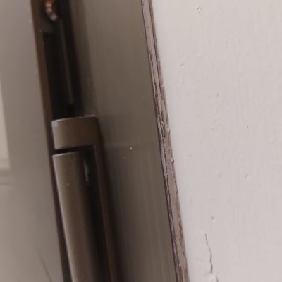 ציר מתכת של תריס על קיר לבן