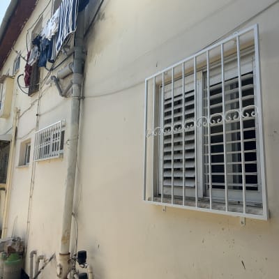 חלון עם סורגים לבנים על קיר חיצוני