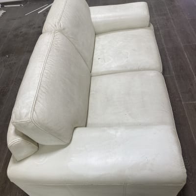 ספה לבנה עם כתמים על המושב והמשענת
