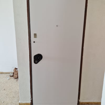 דלת לבנה עם מסגרת חומה, ללא ידית נראית לעין