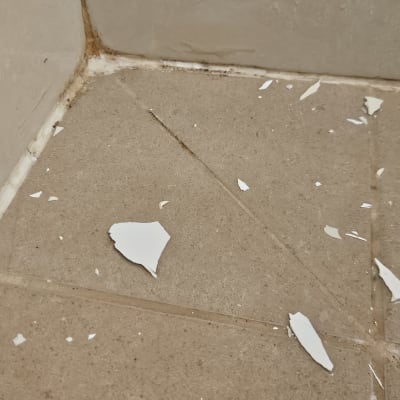 שברי צבע על רצפת אריחים בפינה