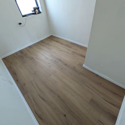 חדר עם רצפת פרקט חדשה וכלים על אדן החלון