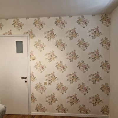 קיר עם טפט פרחוני ודלת לבנה