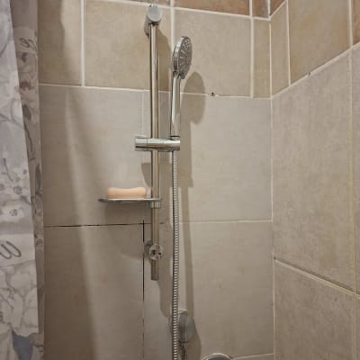 ראש מקלחת ומתקן סבון בחדר אמבטיה